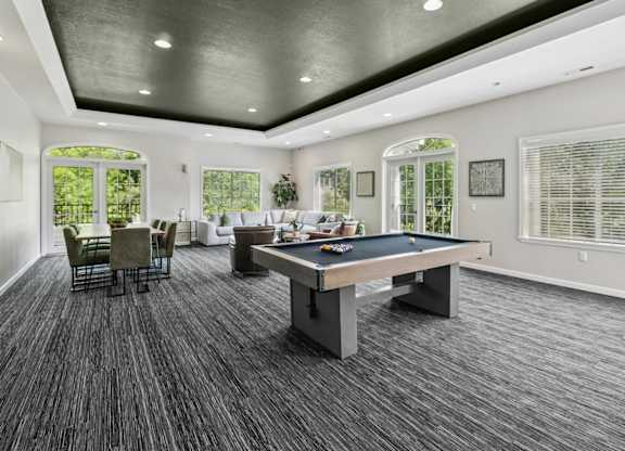 A spacious room with a pool table and a dining table.