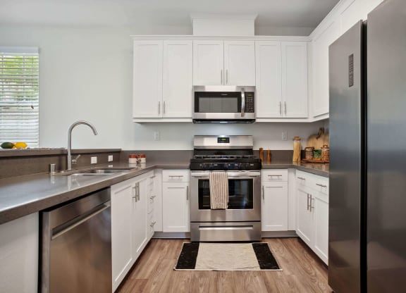 a kitchen with white cabinets and stainless steel appliances at Rancho Belago, Moreno Valley, 92555