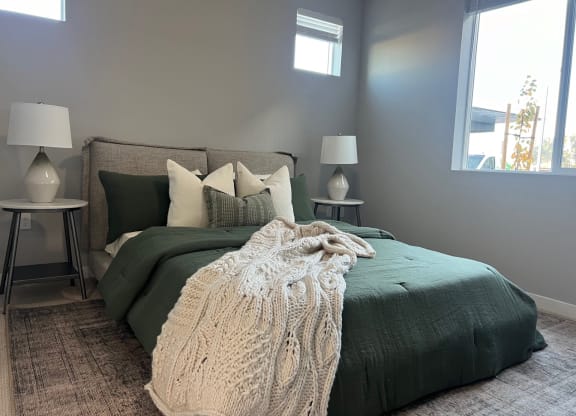 a bedroom with a bed with a blanket and pillows