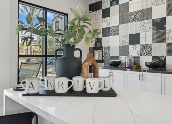 a kitchen with black and white tiles and a table with a plant and a window at Arrive Temecula