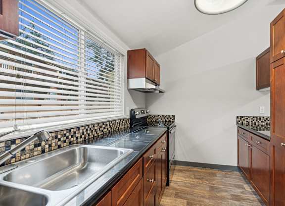 A kitchen with wooden cabinets and a black and white checkered backsplash.