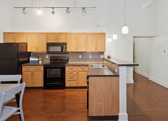 A kitchen with wooden cabinets and black appliances.