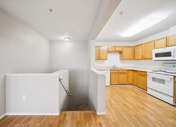 A kitchen with wooden cabinets and a white fridge.
