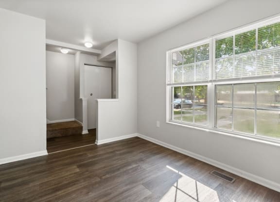 an empty living room with a large window and wooden floorsat Mason Street Townhomes, Grand Rapids, Michigan