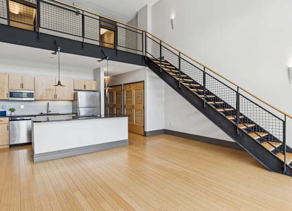 A kitchen with a staircase leading to the upper floor.