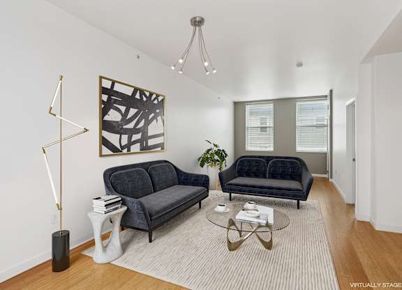 A living room with a black couch and a coffee table.