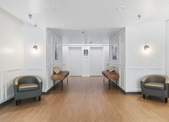 A lobby with two chairs and a bench on either side.