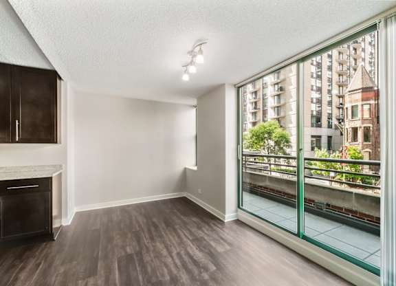 A room with a fireplace and a view of a cityscape through a glass balcony.