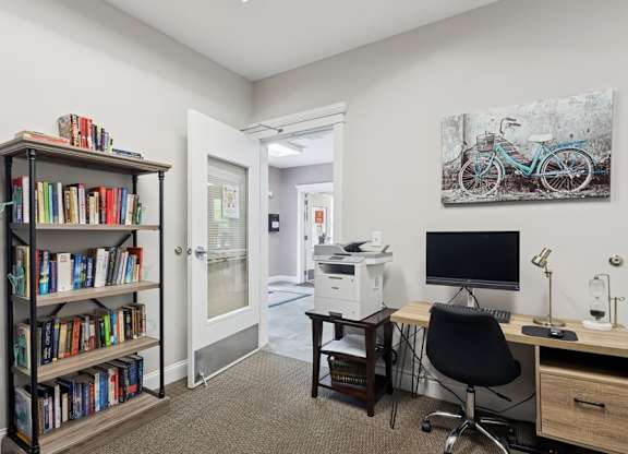 A room with a desk, chair, and bookshelf.