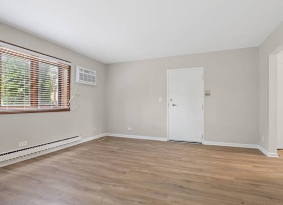 A room with a white door and a window with blinds.
