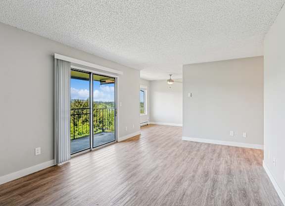 A room with a sliding glass door leading to a balcony.