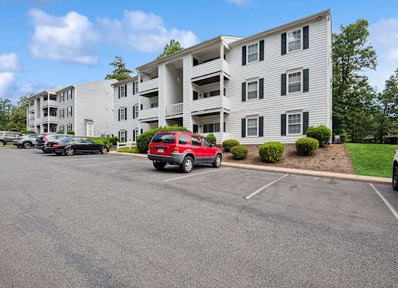 Parking lot in front of a white apartment building.