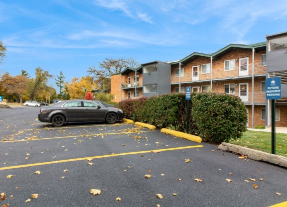 a car parked in a parking lot in front of an apartment building at River Oaks, North Aurora, Illinois