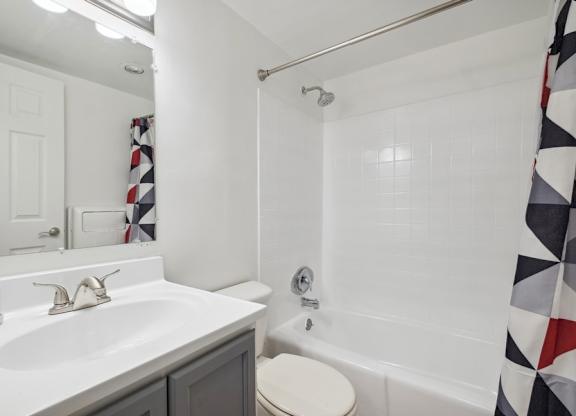 A bathroom with a white sink and a white toilet.
