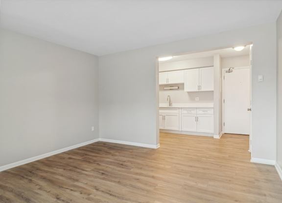 A room with wooden flooring and white walls.