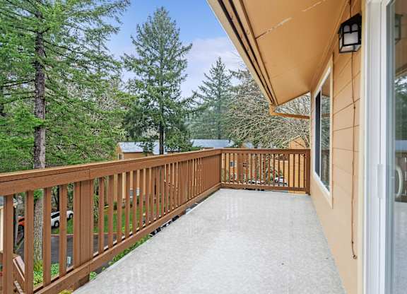 A balcony with a railing and a view of trees.