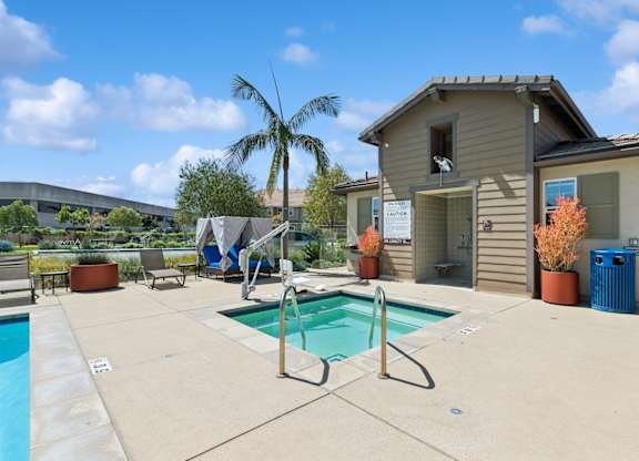 A pool with a slide and a house in the background.
