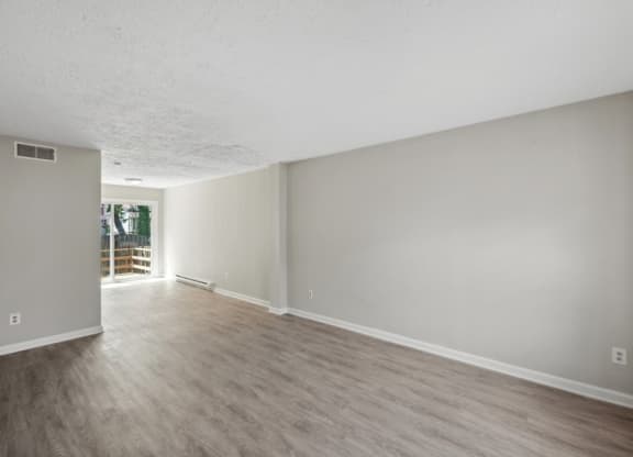 an empty living room with hardwood floors and grey walls at Fort Collier Terrace, Winchester, VA 22601