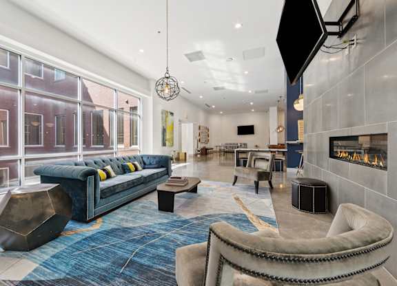 A modern living area with a blue rug and a blue sofasofa.