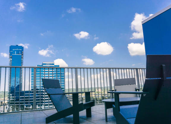 a balcony with a table and chairs and a city in the background at The Rowe, Grand Rapids, Michigan