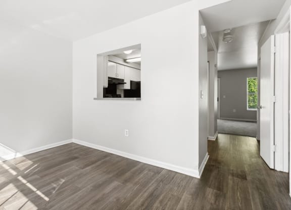 an empty living room with white walls and wood flooring at Mason Street Townhomes, Grand Rapids, MI