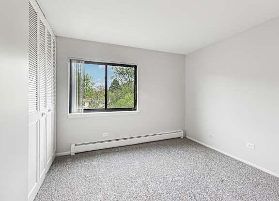 Bedroom with a window and a radiator on the wall.