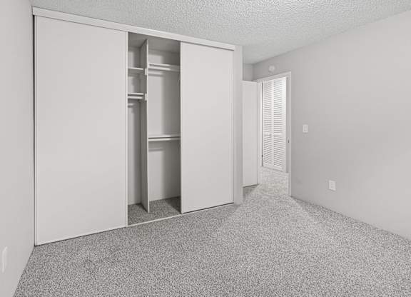 A white room with a white closet and a white door.