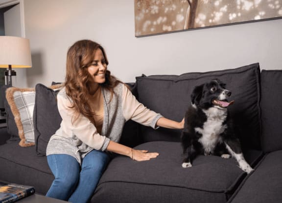 a woman sitting on a couch with her dog at The Township at St. Charles, Illinois