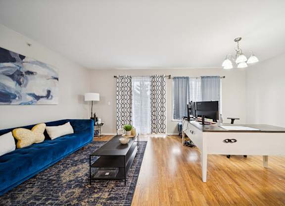 A blue couch sits in a living room with a television and a pool table.