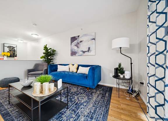 A living room with a blue couch and a black coffee table.