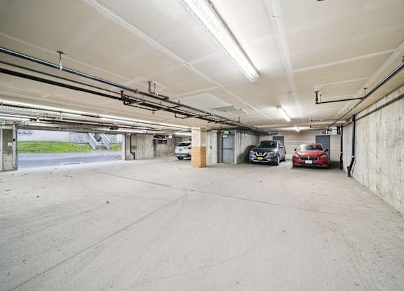 A large, empty parking garage with a red car parked in the distance.