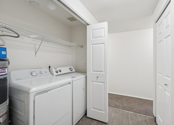 a white laundry room with white appliances and a white door
