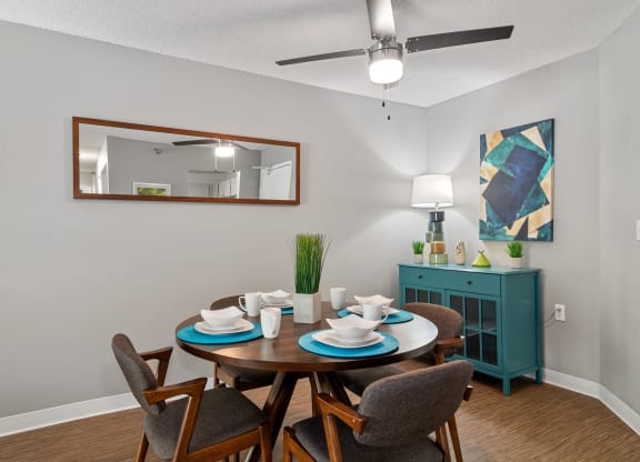 a dining room with a table and chairs and a ceiling fan