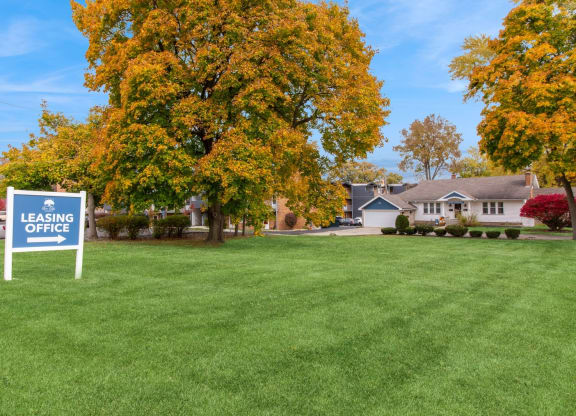 a lawn with a leasing office sign in front of a house at River Oaks, Illinois
