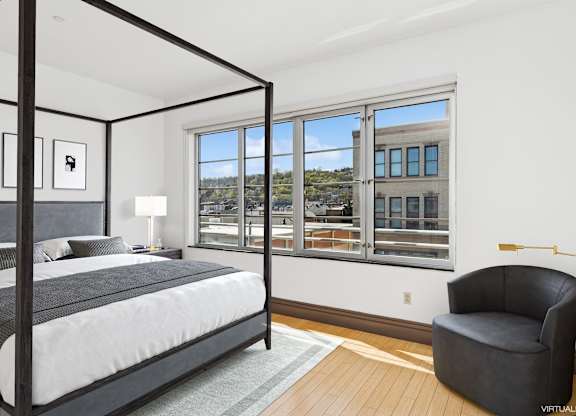 A bedroom with a large bed and a chair.