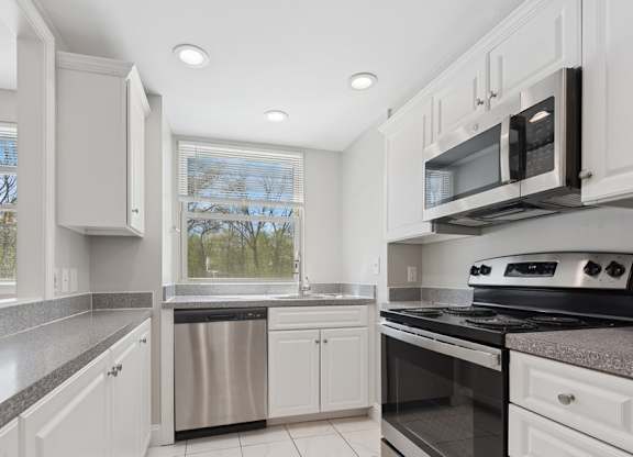 A kitchen with white cabinets and stainless steel appliances.