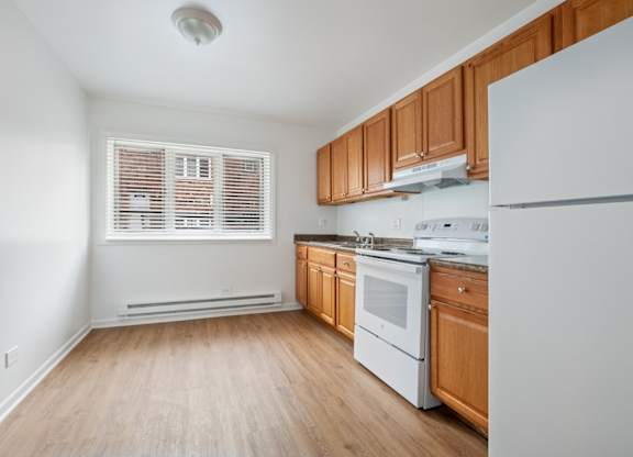 A kitchen with wooden cabinets and white appliances.