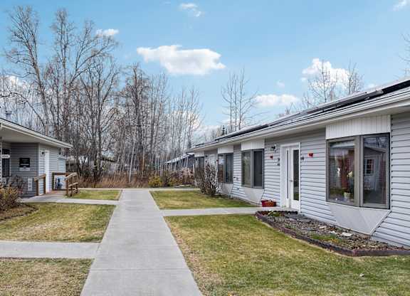 A row of houses with a sidewalk in between.