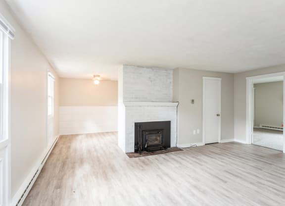 living room with a fireplace and wooden floors at Stonebridge, Connecticut, 06029