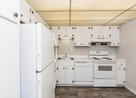 A spacious kitchen with white kitchen appliances and white cabinets