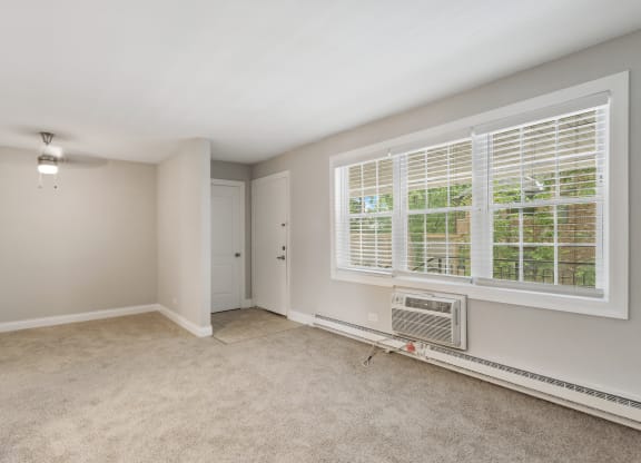 a bedroom with a large window and an air conditioner at The Hinsdale, Illinois, 60521