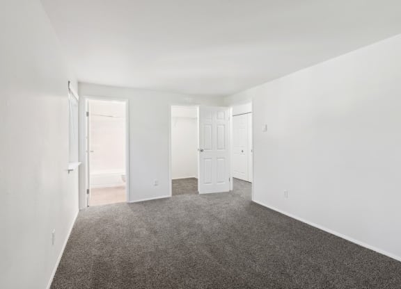 an empty room with carpet and white walls
