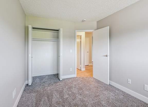A room with a grey carpet and white walls.