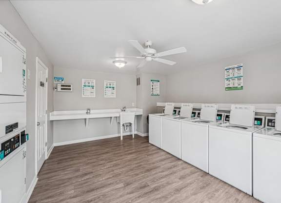 A laundry room with a row of washers and dryers.