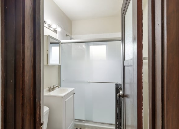 a white bathroom with a shower and a sink