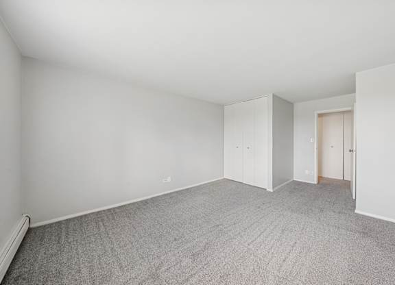 A room with grey carpet and white walls.
