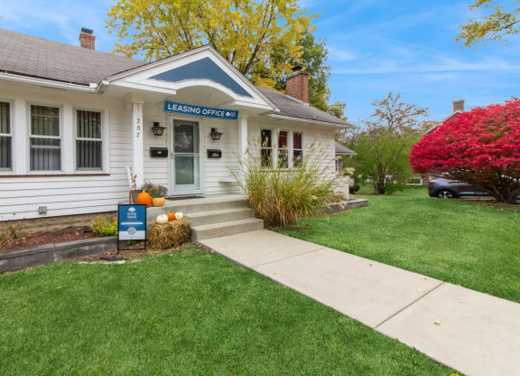 a white house with a lawn and a sidewalk in front of it at River Oaks, North Aurora