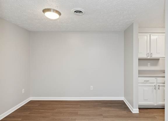 A room with a white ceiling and wooden floor.
