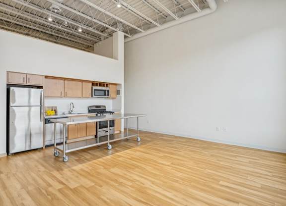 A kitchen area with a refrigerator, microwave, and a table with chairs.