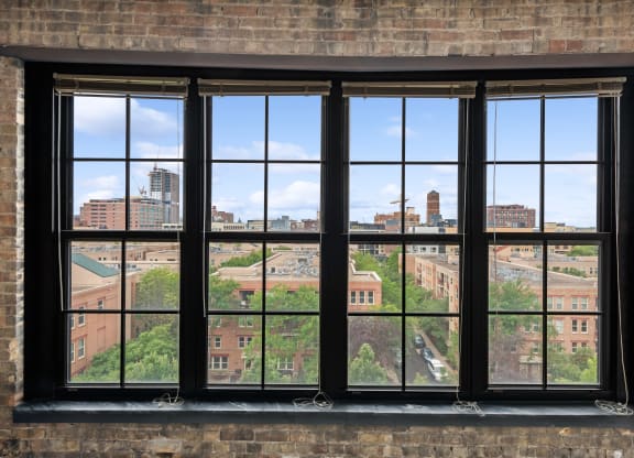 a large window in a brick wall with a view of the city at Gaar Scott Historic Lofts, Minnesota, 55401